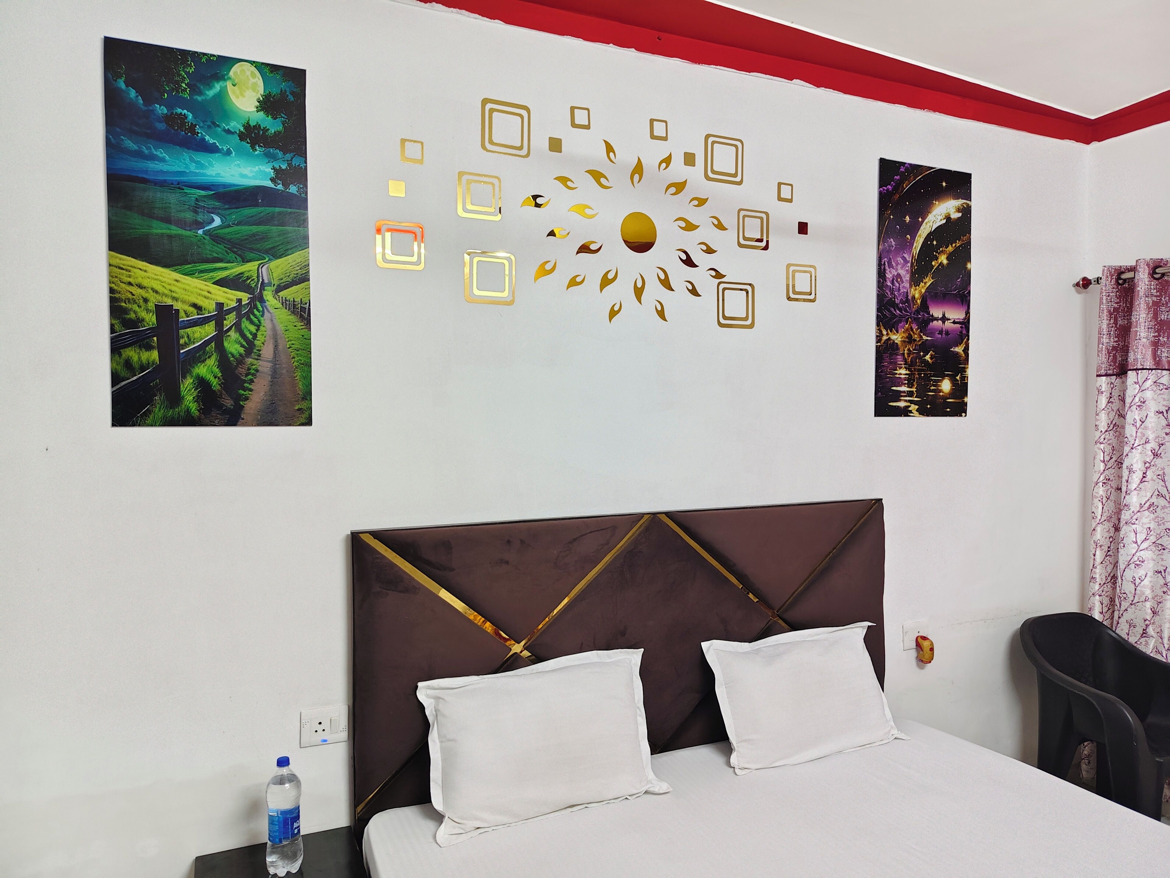 A bedroom with a bed, two pillows, a water bottle, and two wall art pieces.