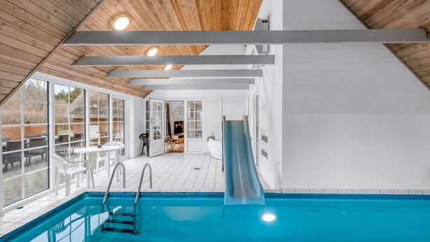 A swimming pool with a slide, wooden ceiling, and large windows. - "Aagot" - 1.7km from the sea by Interhome (Ulfborg)