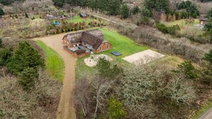 A rural property with a large house featuring a thatched roof, a fenced yard, and a gravel driveway. - "Aagot" - 1.7km from the sea by Interhome (Ulfborg)