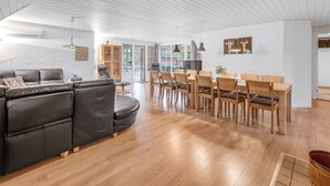 A modern living room with a leather sofa, wooden dining table, and chairs. - "Aagot" - 1.7km from the sea by Interhome (Ulfborg)