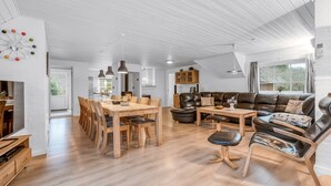 A spacious living area with a wooden dining table, leather sofa, and a modern ceiling design. - "Aagot" - 1.7km from the sea by Interhome (Ulfborg)