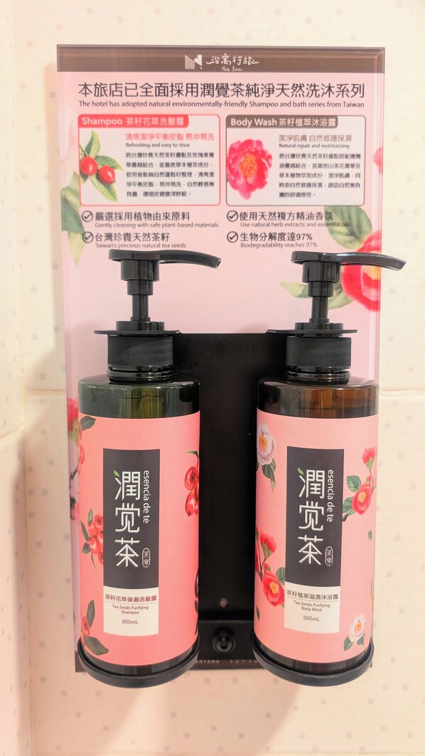 A display of two 500mL bottles of tea seed purifying shampoo and body wash, packaged in a pink box with floral designs and Chinese text. - Yen Inn (New Taipei City)