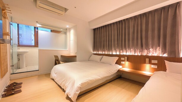 A modern bedroom with a large bed, a bedside table, a mirror, and a window with curtains. - Yen Inn (New Taipei City)