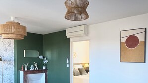 Una sala de estar moderna con una mesa redonda de comedor, paredes verde oscuro y un diseño minimalista.