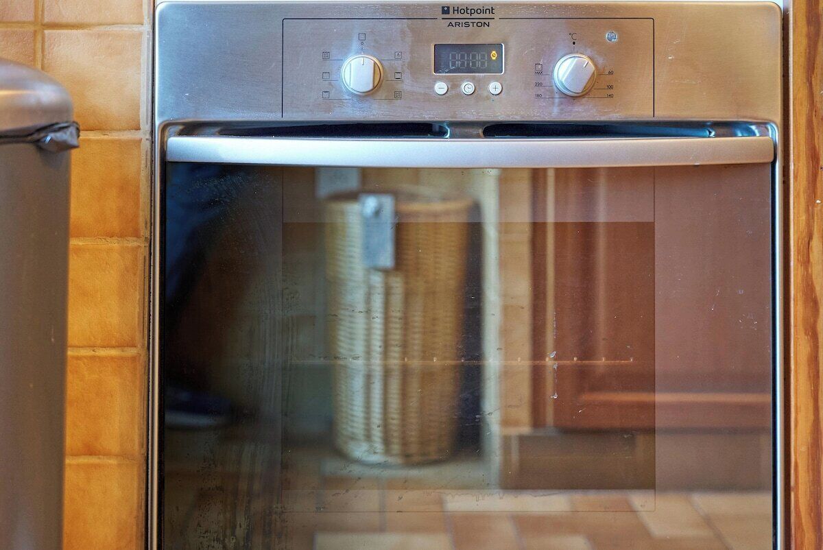 Un horno con pantalla digital, mandos de control y puerta de cristal.