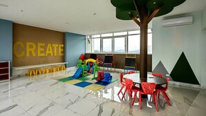 A spacious indoor play area with a large window, a play structure, and a table with chairs. - 80m² Luxury Ocean View Apartment PH The Sands, Next to Hilton (Panama City)