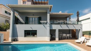 Ein zweistöckiges Gebäude mit Schwimmbad, Außenbereich und Balkon.