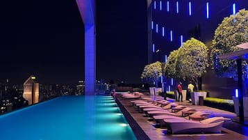 Una piscina al aire libre, sombrillas, tumbonas