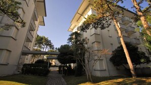 Ein modernes Gebäude mit einem zentralen Innenhof, umgeben von Bäumen und einem überdachten Gang.