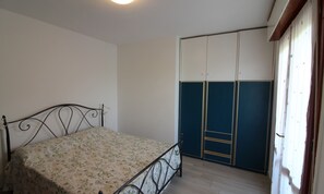 Une chambre à coucher avec un lit, une armoire et une fenêtre.