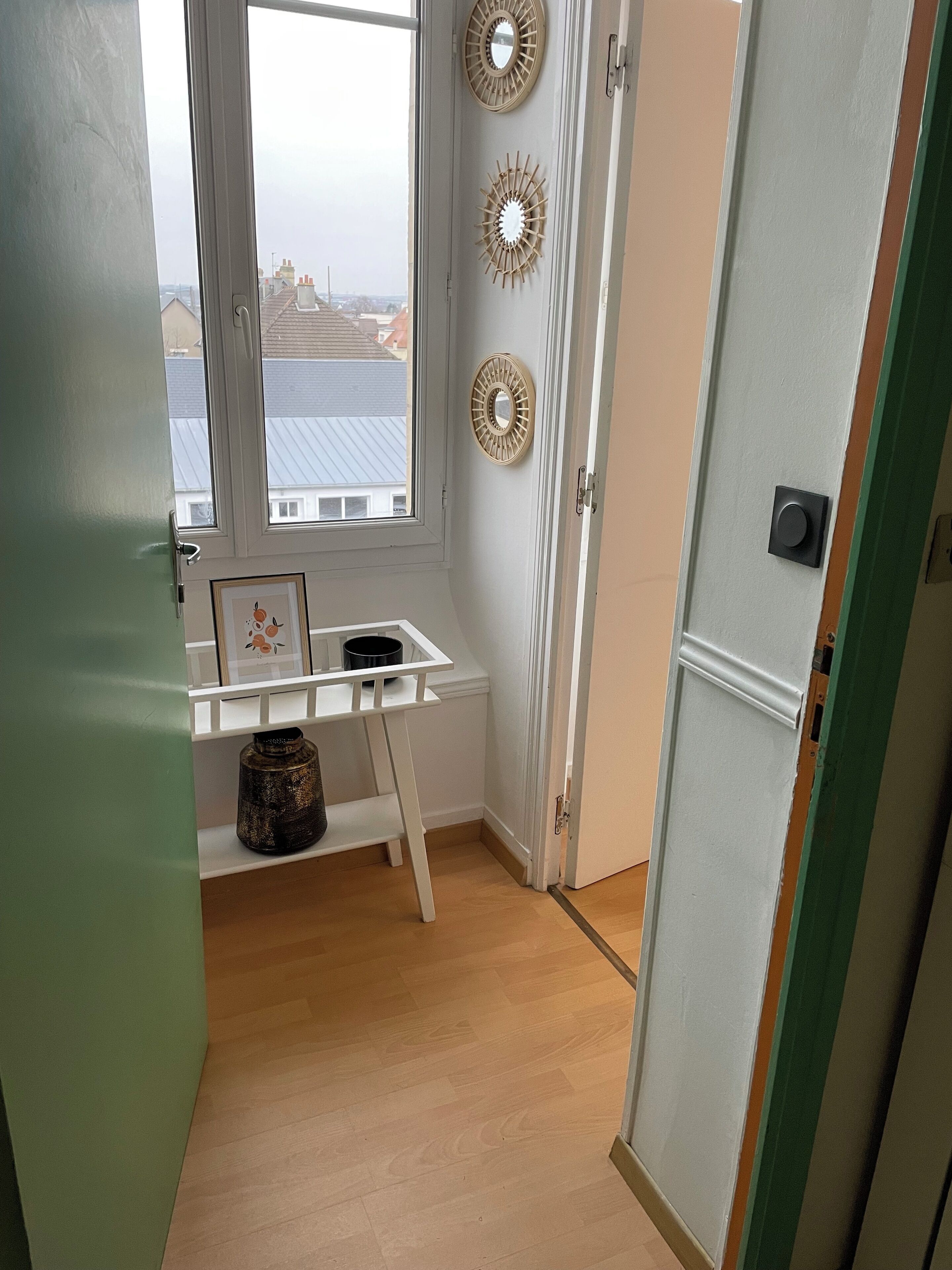 A small kitchen with a window, a white countertop, and a door.