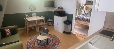 Um espaço compacto para viver, com cozinha compacta, área de refeições e quarto.