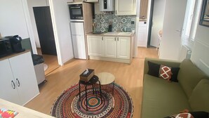 A compact living space with a kitchenette, a dining area, and a sofa. - A cocoon in the presbytery (with private parking)  (Caen)