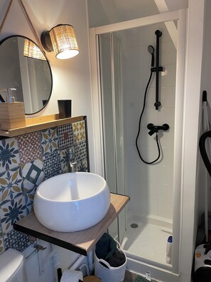 Een douche, handdoeken, zeep, toiletpapier