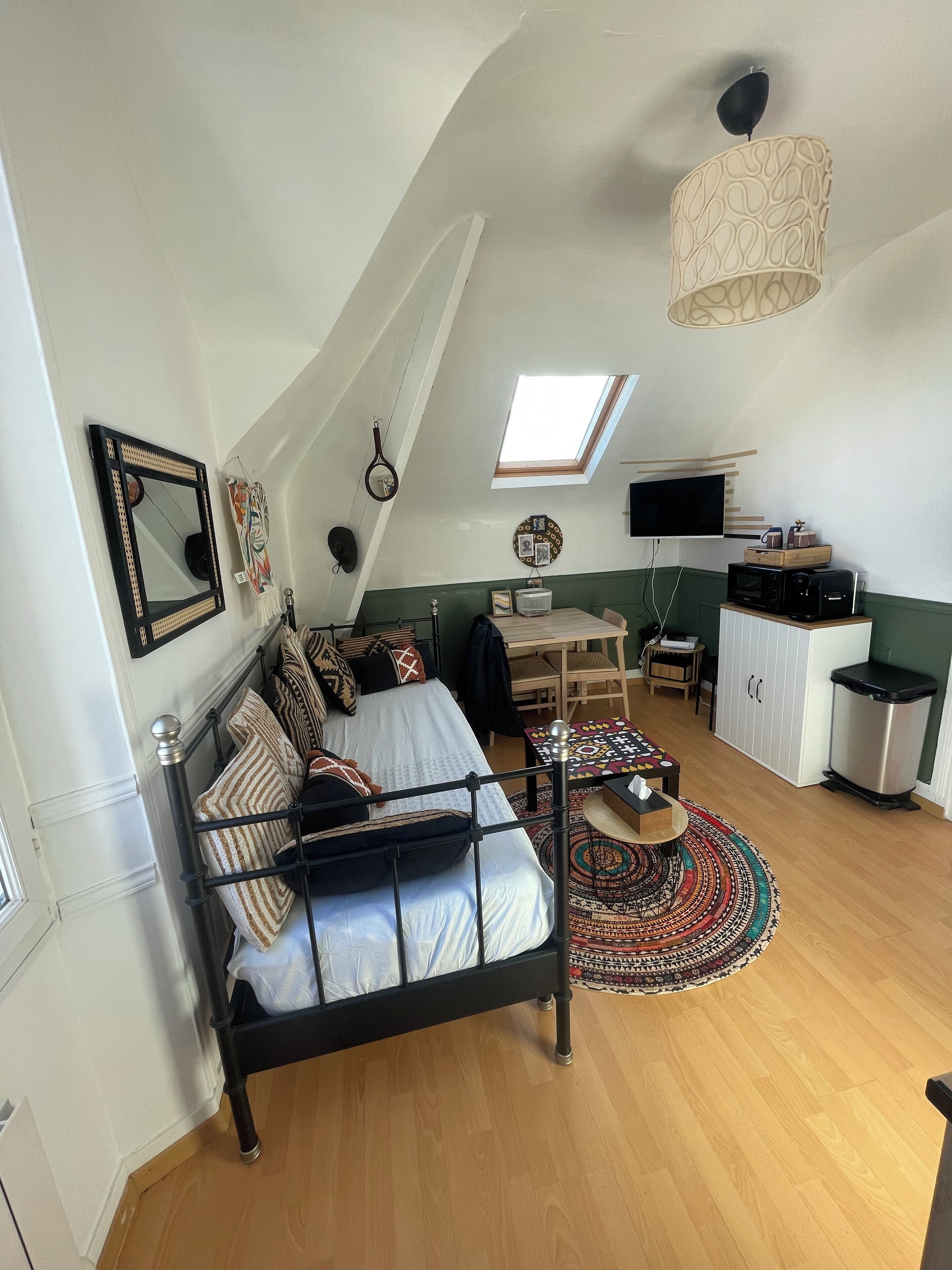 Ein Schlafzimmer mit einem Bett, einem Schreibtisch, einem Stuhl, einem Fernseher und einem Fenster.