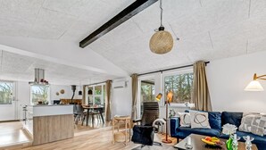 Ein großzügiger Wohnbereich mit einer Couch, einem Couchtisch und einem Essbereich mit Stühlen und einem Tisch.