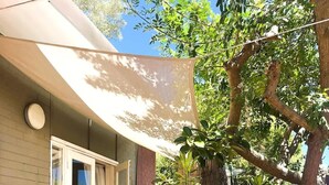 A patio area with a table and chairs, a potted plant, and a small fountain. - 45 Garden Guest Suite Studio (Bassendean)