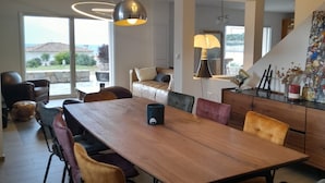 A spacious dining area with a long wooden table, multiple chairs, and a modern pendant light fixture. - House Pietrosella Sea view 50 m from the beach (Pietrosella)