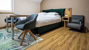 A hotel room with a bed, a desk, two chairs, a wooden floor, and a window. - Nice apartment for 2 guests with WIFI, TV and terrace (Jilemnice)