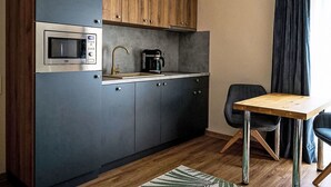 A compact kitchen with a built-in microwave, coffee maker, and wooden cabinets. - Nice apartment for 2 people with WIFI, TV and terrace (Jilemnice)