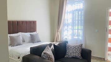 Suite Deluxe, vista al patio | 1 habitación, tabla de planchar con plancha y wifi gratis