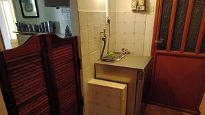 Uma cozinha pequena com porta de madeira, pia e bancada.