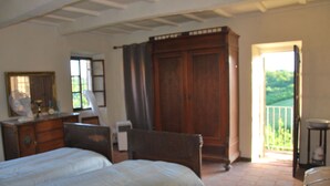Um quarto com cama, penteadeira e um guarda-roupa de madeira grande.