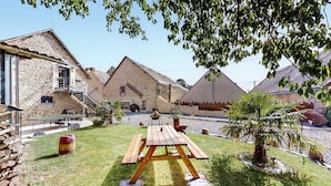 A rustic stone building with a wooden staircase, a picnic table, and a fenced area with trees. - 4 bedroom beautiful home in Neuilly le Vendin (Neuilly le Vendin)