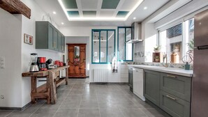 A modern kitchen with grey cabinets, a wooden table, and a built-in oven. - 4 bedroom beautiful home in Neuilly le Vendin (Neuilly le Vendin)