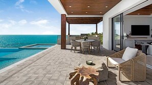 Une terrasse extérieure moderne dotée d’une piscine, d’un espace repas et d’un coin salon.