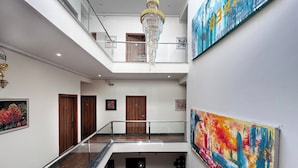 A multi-level interior with a marble staircase, wooden doors, and artwork on the walls. - Haven Hotel Sector 31,Gurugram (Gurugram)
