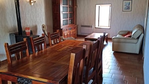 Un vaste espace dédié à la salle à manger, avec une grande table et des chaises en bois, un meuble encastré et une fenêtre laissant entrer la lumière naturelle.