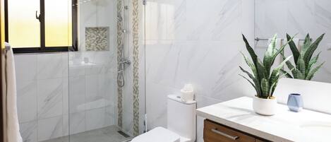 Een douche, handdoeken, zeep, toiletpapier