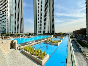 A modern hotel with a large swimming pool, high-rise buildings, and a well-maintained outdoor area. - Bright and Exquisite 1-Bedroom in Downtown views 2 (Dubai)