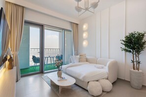 A modern bedroom with a large bed, a small table, and a potted plant. - Bright and Exquisite 1-Bedroom in Downtown views 2 (Dubai)