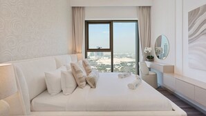 Una habitación de hotel moderna con una cama grande, vistas a la ciudad y una decoración minimalista.