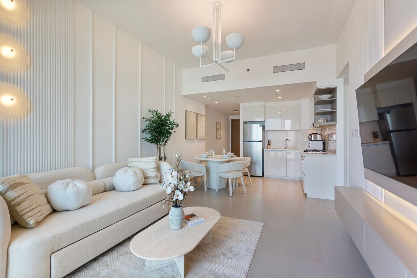 A modern living room with a sofa, coffee table, and dining area.