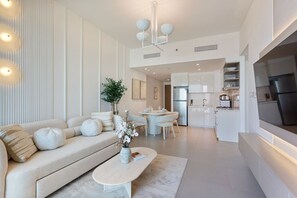 A modern living room with a sofa, coffee table, and dining area.