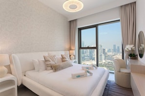 A modern hotel room with a large bed, a city view, and a minibar. - Bright and Exquisite 1-Bedroom in Downtown views 2 (Dubai)