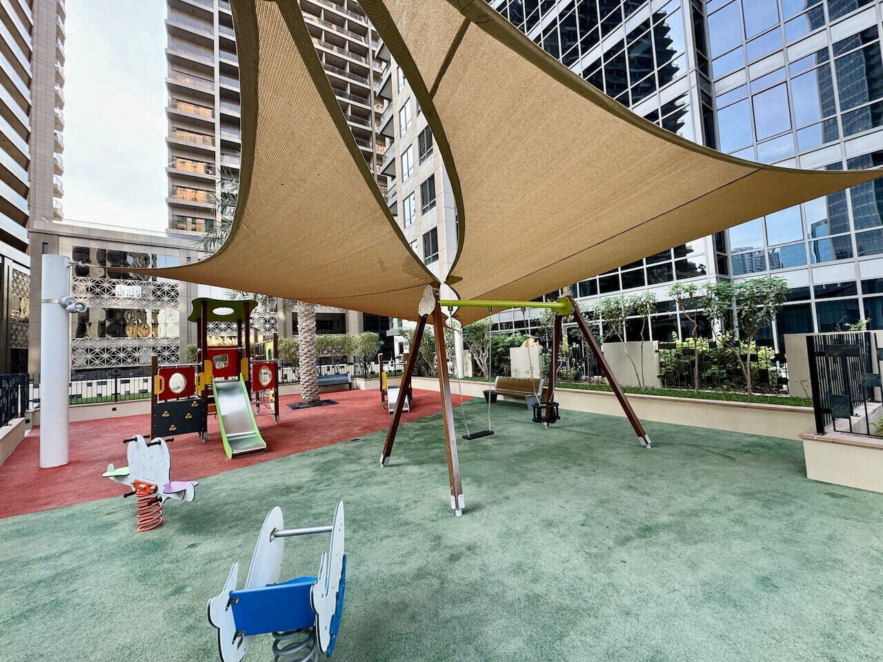 Un espace de jeux intérieur équipé de balançoires, de toboggans et de structures d’escalade.