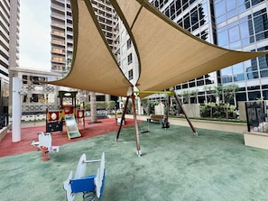 An indoor playground with a swing set, slides, and climbing structures.
