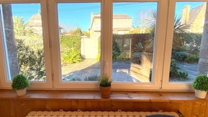 Una habitación con un banco de madera, un radiador y una ventana de tres cristales.
