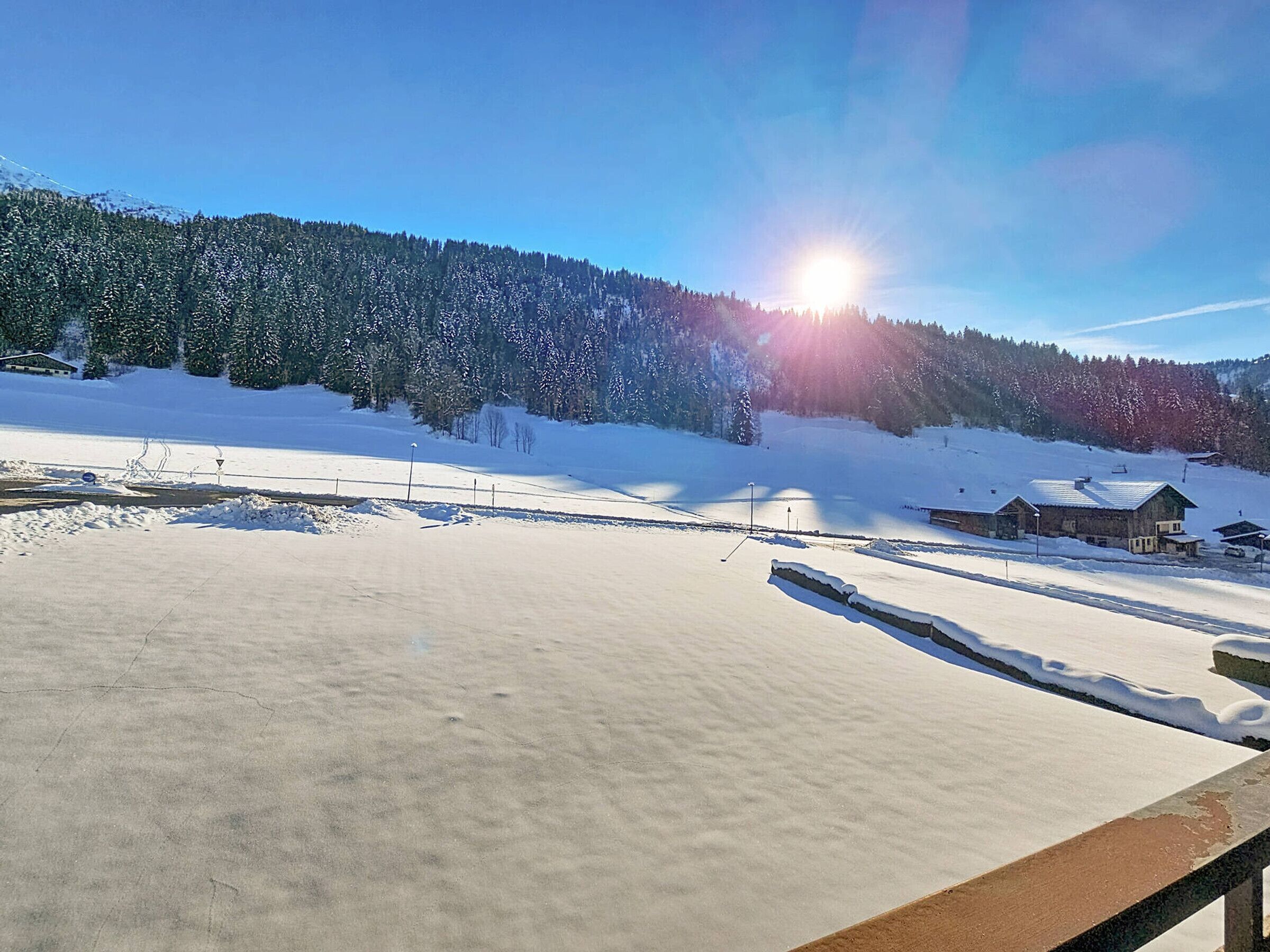 Un paysage enneigé avec une cabane en bois et un ciel dégagé.