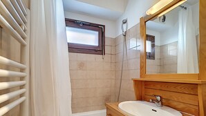 Un baño con bañera, lavabo y espejo.