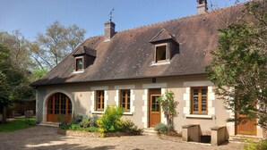 A two-story house with a brick exterior, a large arched entrance, and a paved driveway. - Charming Cottage with Spa, Billiards, Garden and Ping-Pong (Vinon)