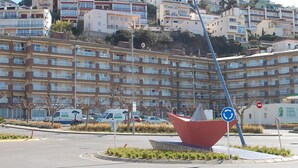 A multi-story residential building with balconies, a roundabout with a red sculpture, and a street sign indicating a no-entry zone. - Apartment with Wi-Fi & Parking, ideal for 4 in Roses (Roses)