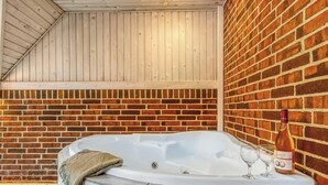 A spa area with a hot tub, a bottle of wine, and two glasses.