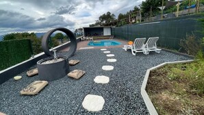 A pool area with a circular water feature, stepping stones, and lounge chairs. - La Cigarrita Guest House - Douro Valley (Peso da Régua)