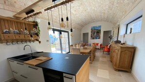 Una cuina moderna amb una illa central, armaris de fusta i lluminàries penjants.