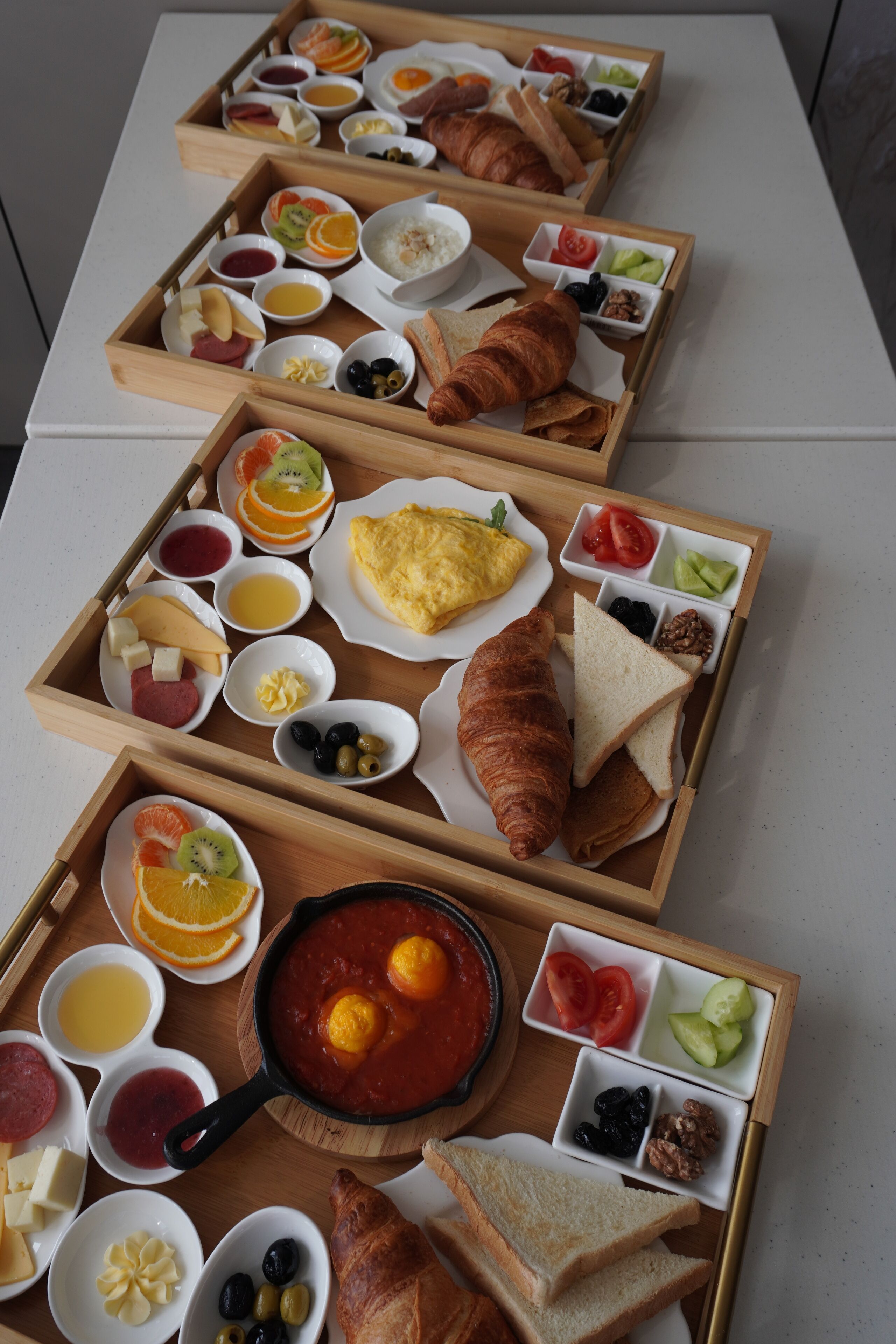A breakfast buffet with various food items and drinks arranged on wooden trays.
